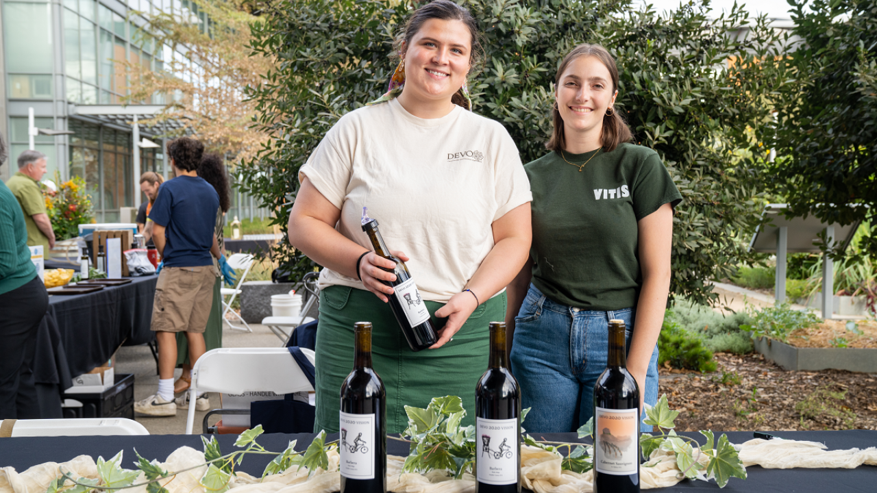 two wine uc davis wine students from DEVO holding wine bottles