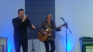 Man singing and women playing guitar 