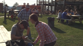 People sitting at picnic tables outside