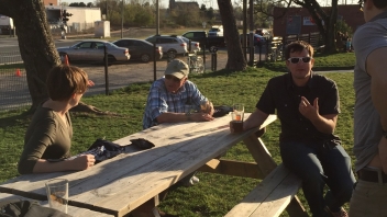 People sitting at picnic tables 