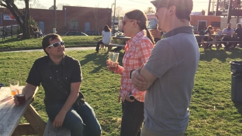 People talking at picnic tables 