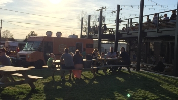 People sititng at picnic tables with food truck in the back