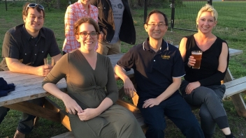 People sitting and smiling at picnic tables 