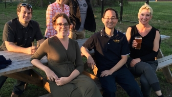 People sitting and smiling at picnic tables 