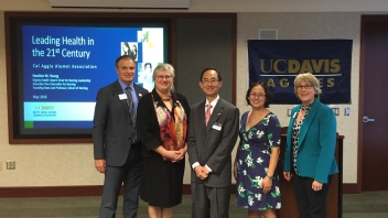People standing inside next to podium and powerpoint 