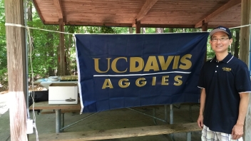 Man standing next to UCD flag 