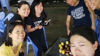 Group standing near a grill 