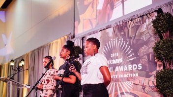 Three people standing on stage