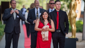A group of guests walk down the red carpet.
