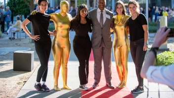 Chancellor Gary May poses for a photo on the red carpet with student performers.
