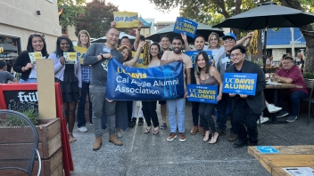 Silicon valley network meet up with various members posing with alumni and uc davis signs.