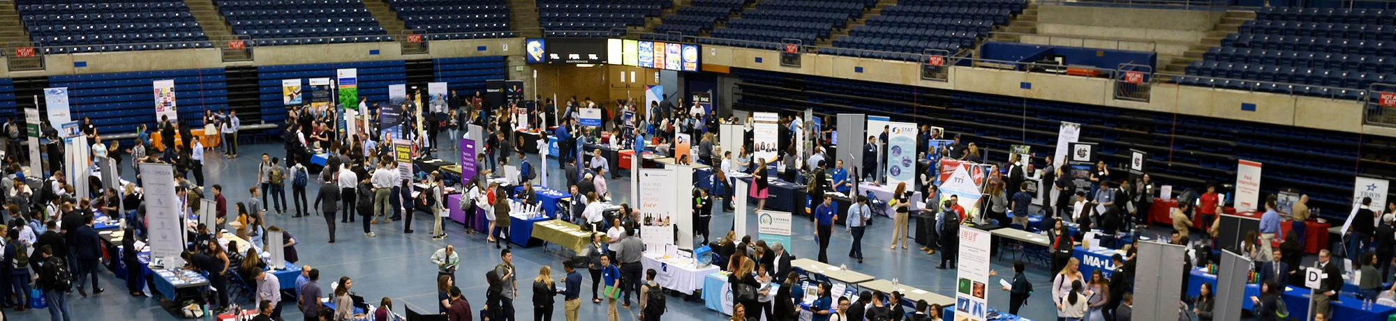 Aerial shot of job booths set up in rows along the University Credit Union Pavilion floor with many people milling about.
