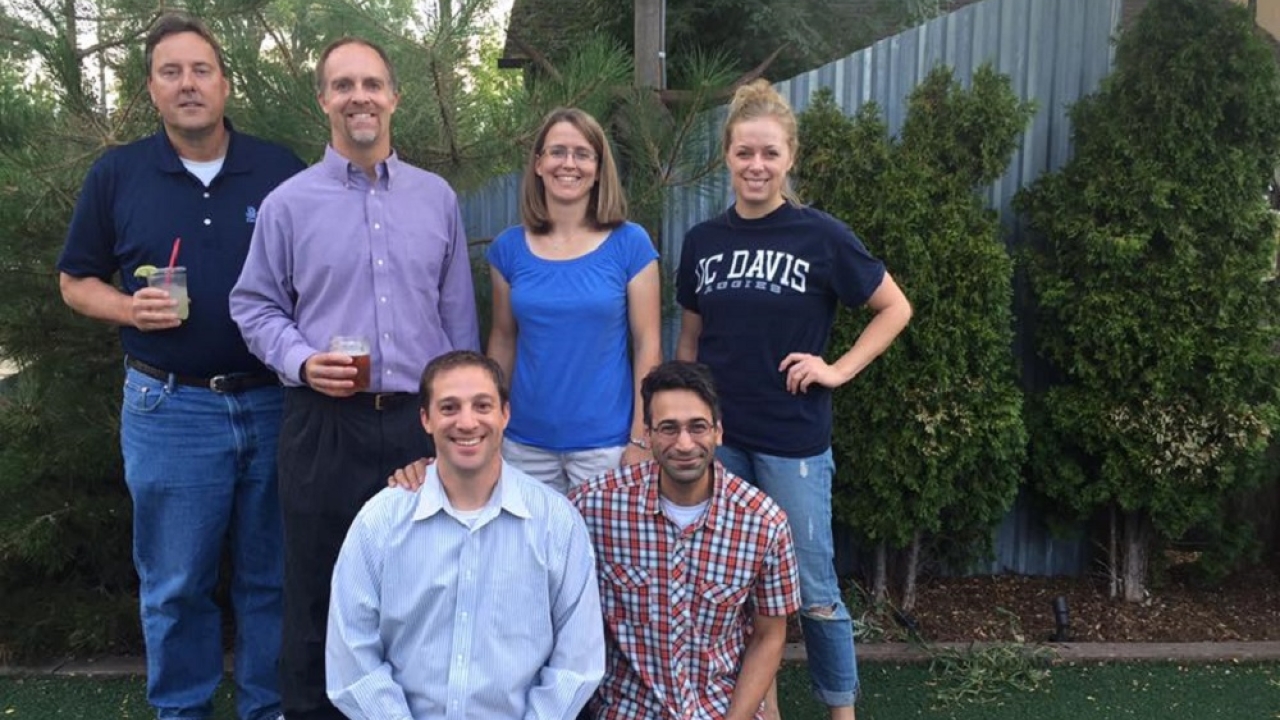 Five alumni smiling