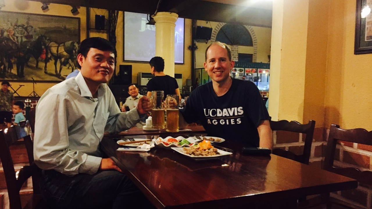 Two men at a table smiling