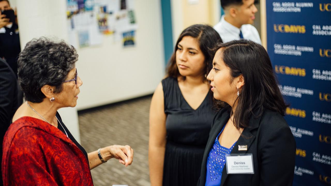 UC Davis students interacting with an alumna at a career fair