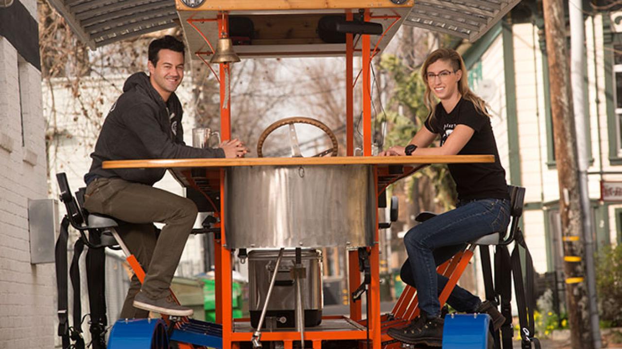 Chris and Sarah Ferren-Cirino own Sac Brew Bike and Boat. Two people sitting on brew bike