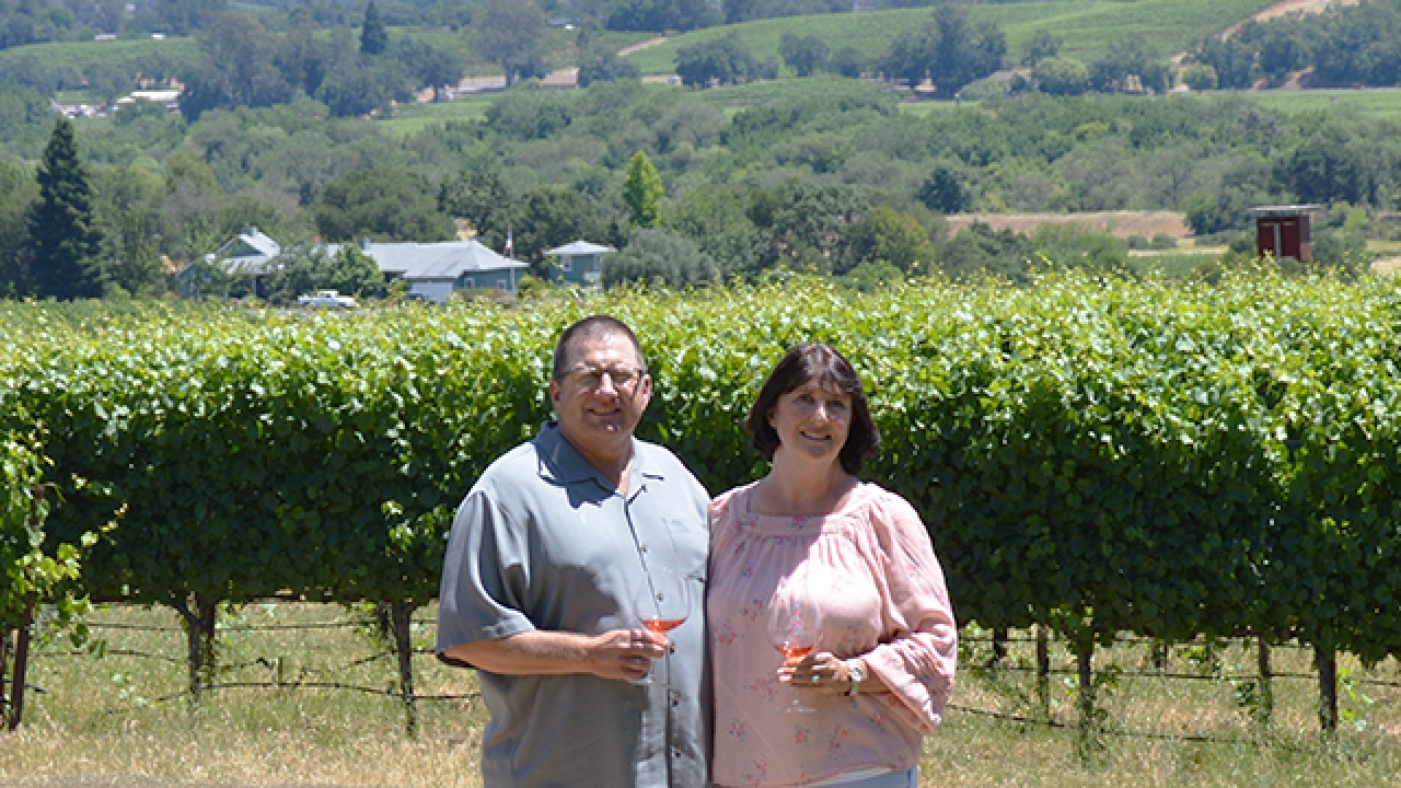 John Bucher '84 and his wife Diane of Bucher Wines posing in front of their vineyard