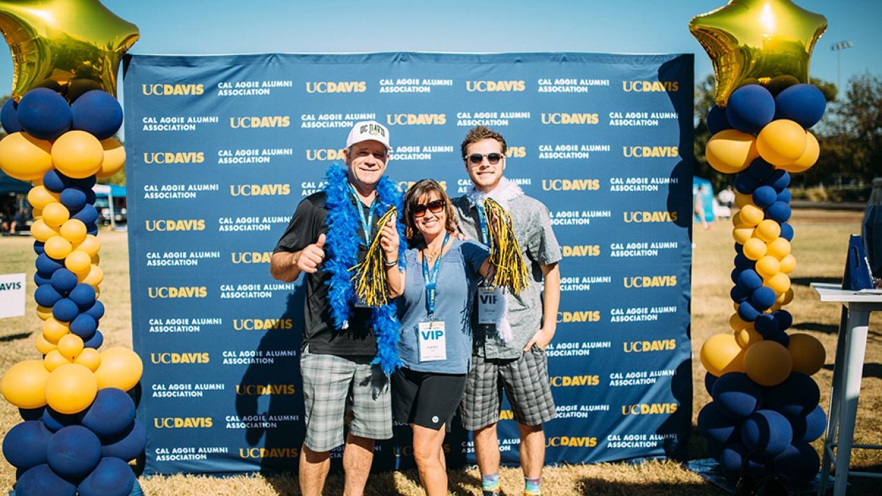 Family standing in front of UC Davis backdrop