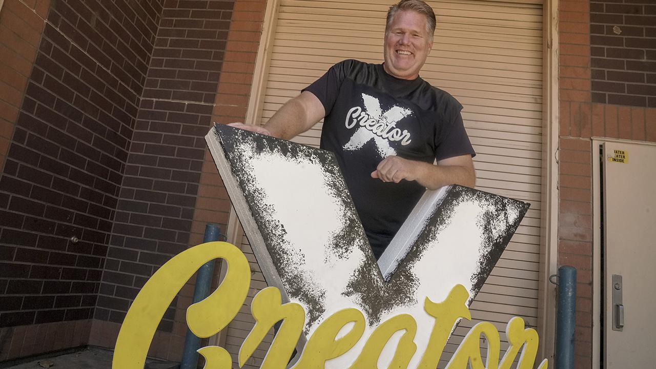 Shawn Sullivan brought animation to Sheldon High School and guides students into successful art careers. Shawn Sullivan standing with a Creator X sign