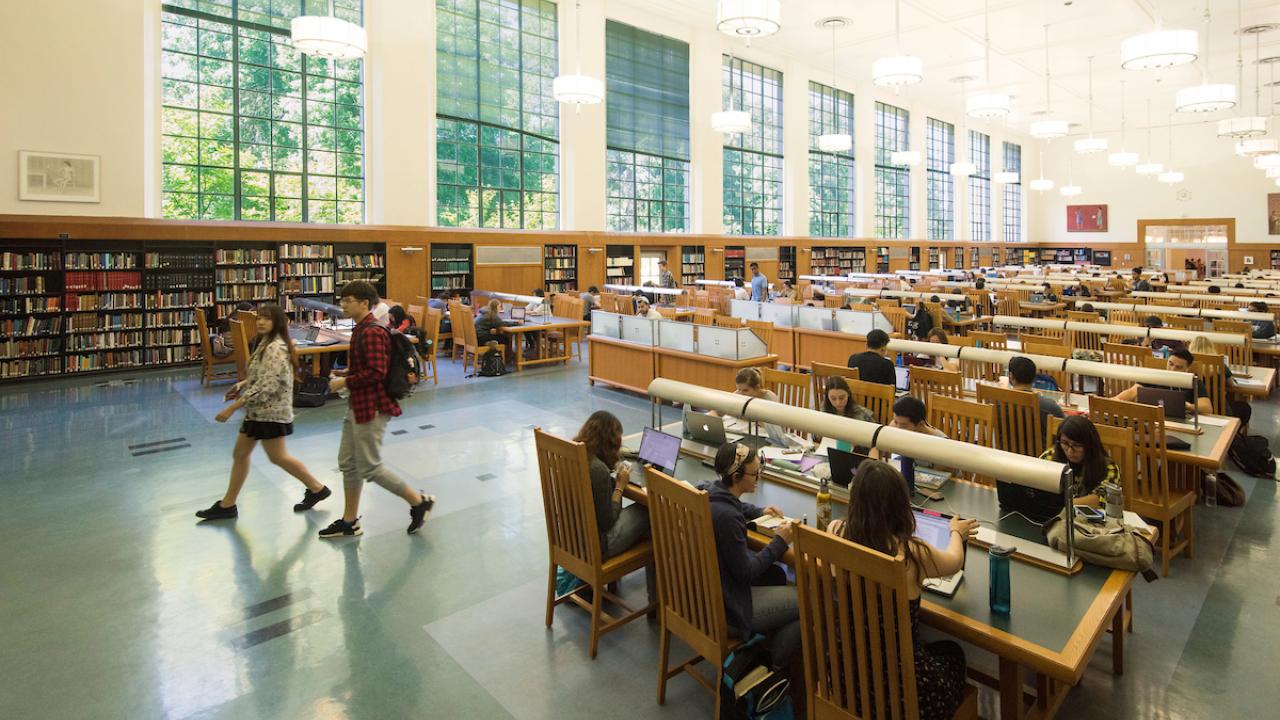 Students studying and walking around the reading room in Shield Library at UC Davis