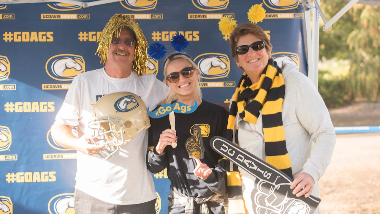 Parents with a student against a UC Davis backdrop