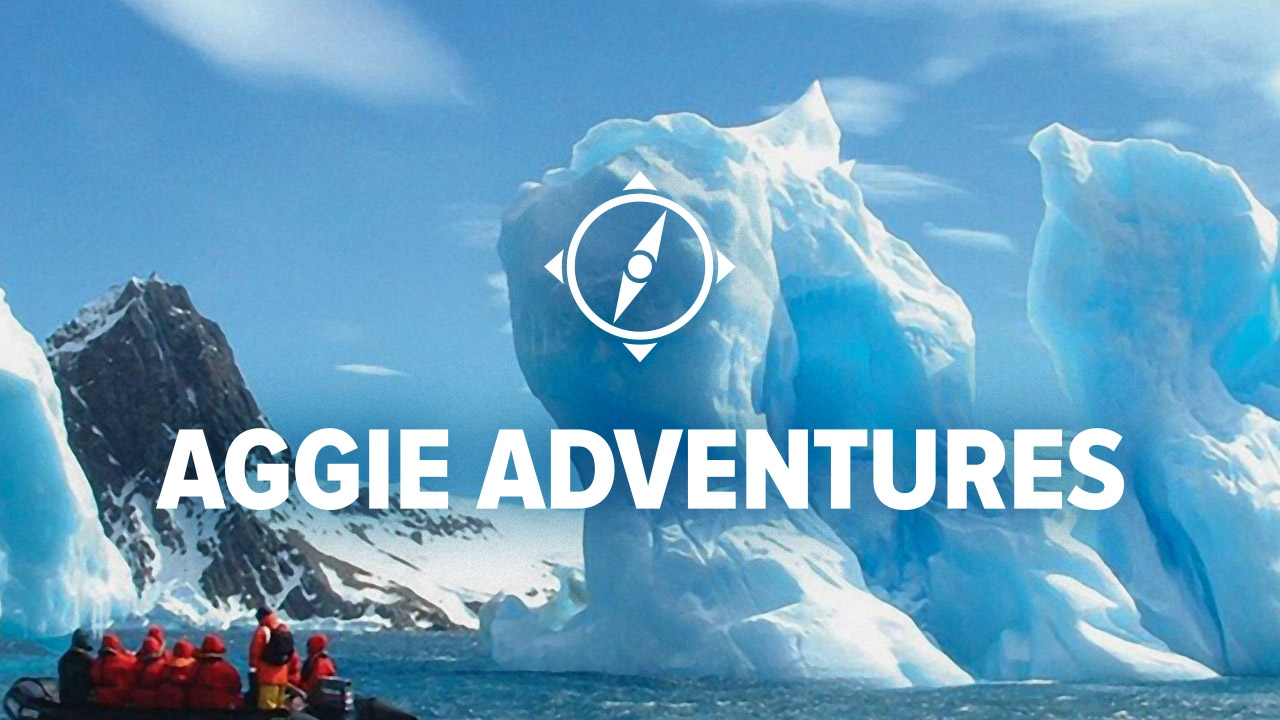 Several travelers approach a glacier on a draft in Antarctica.