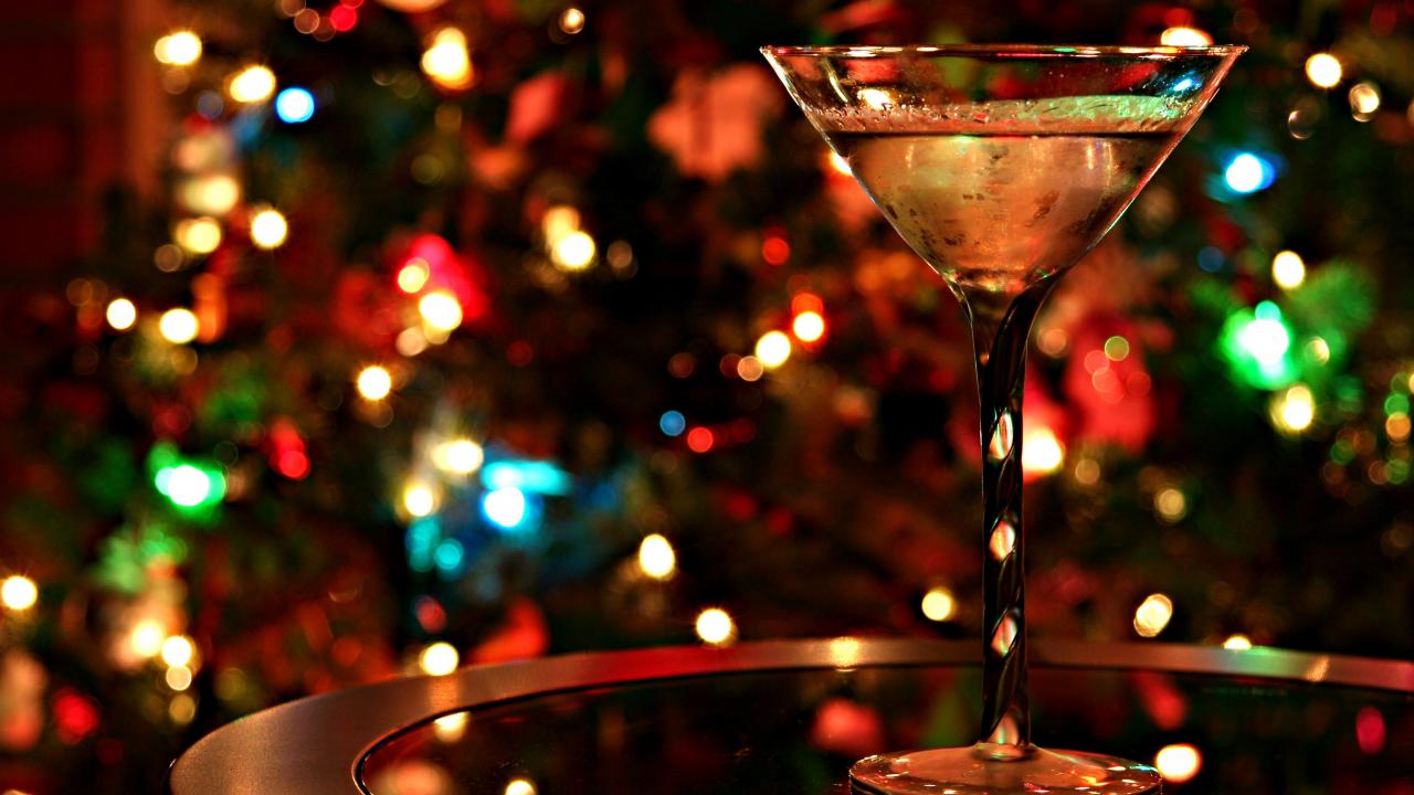 photo of a martini glass in front of a background of twinkle lights