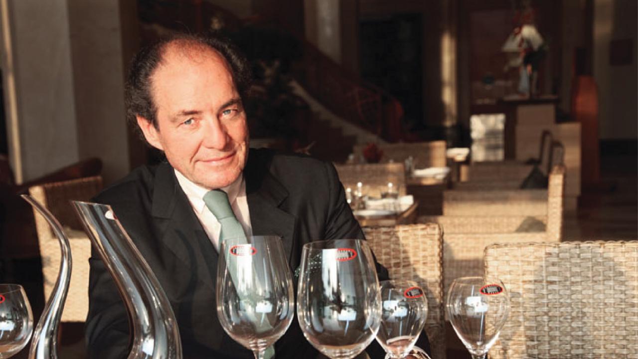 Georg Riedel with wine glasses at a table