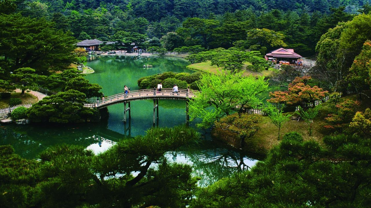 picture of a bridge over a pond surrounded by water