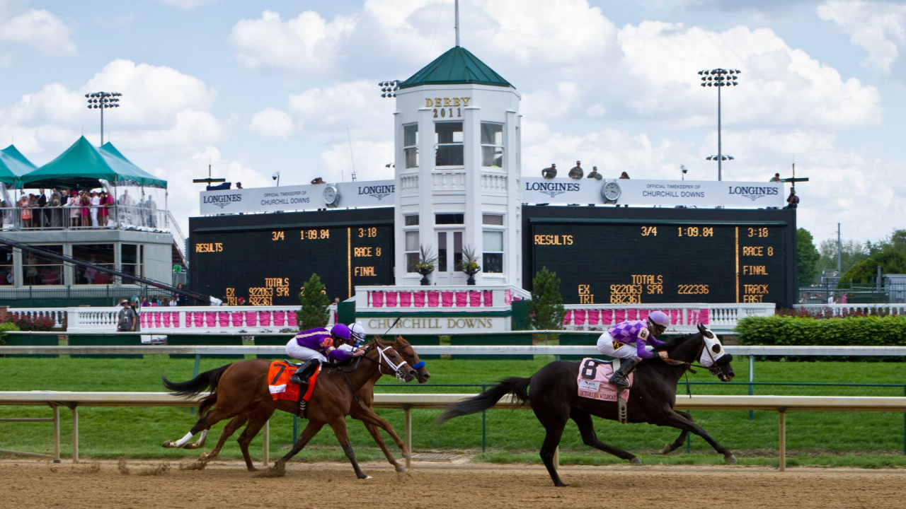 Three horses racing at the Kentucky Derby.