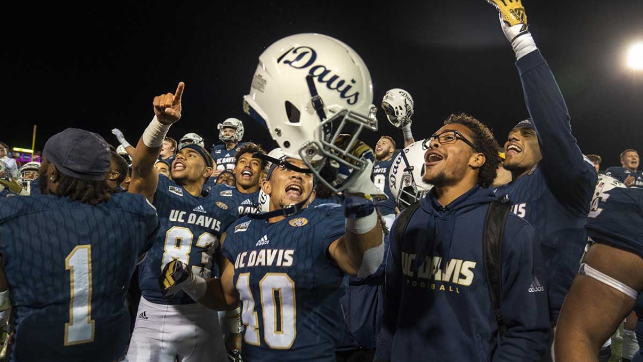 UC Davis football players celebrating on a football field