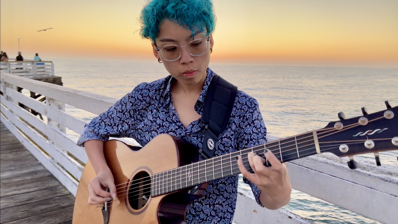 Kat playing the guitar at San Diego Pacific Beach Pier