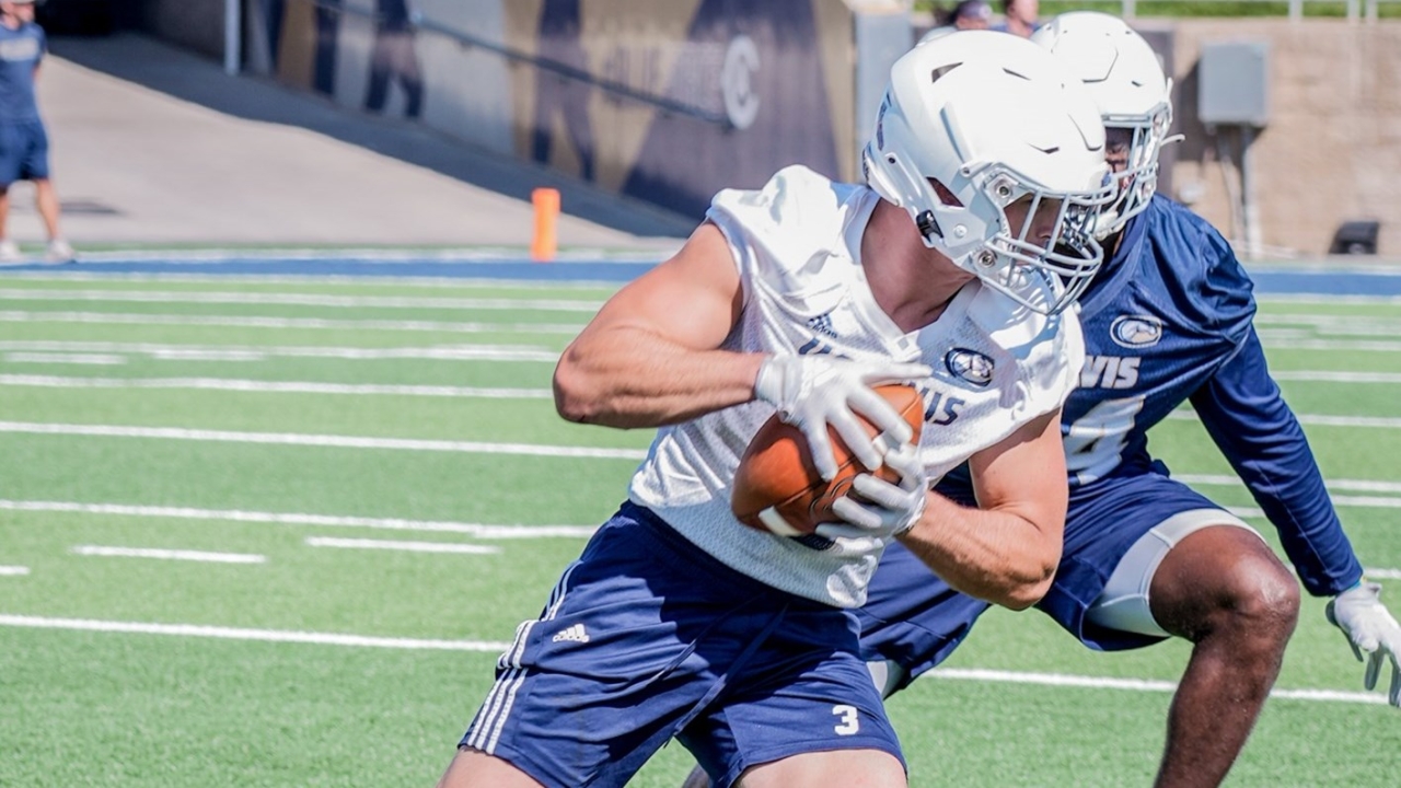 uc davis football player holding football