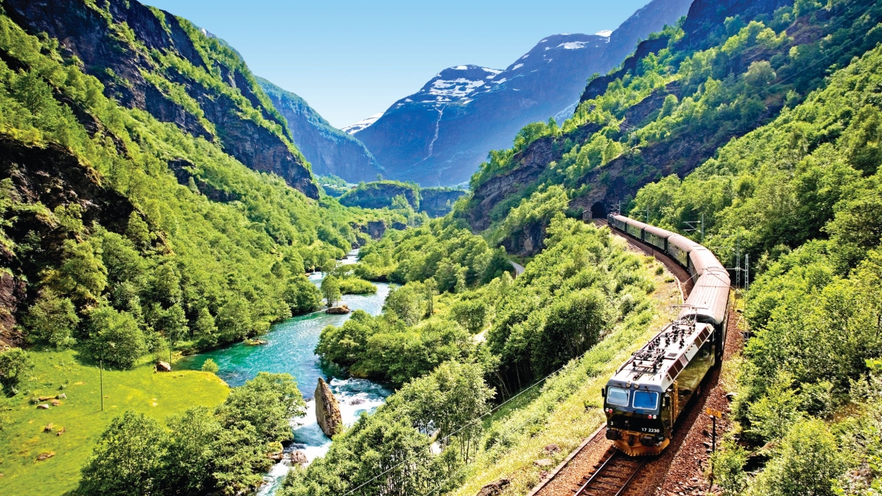 Beautiful view of the Flåm railway train passing through the mountains of Flåmsdalen.