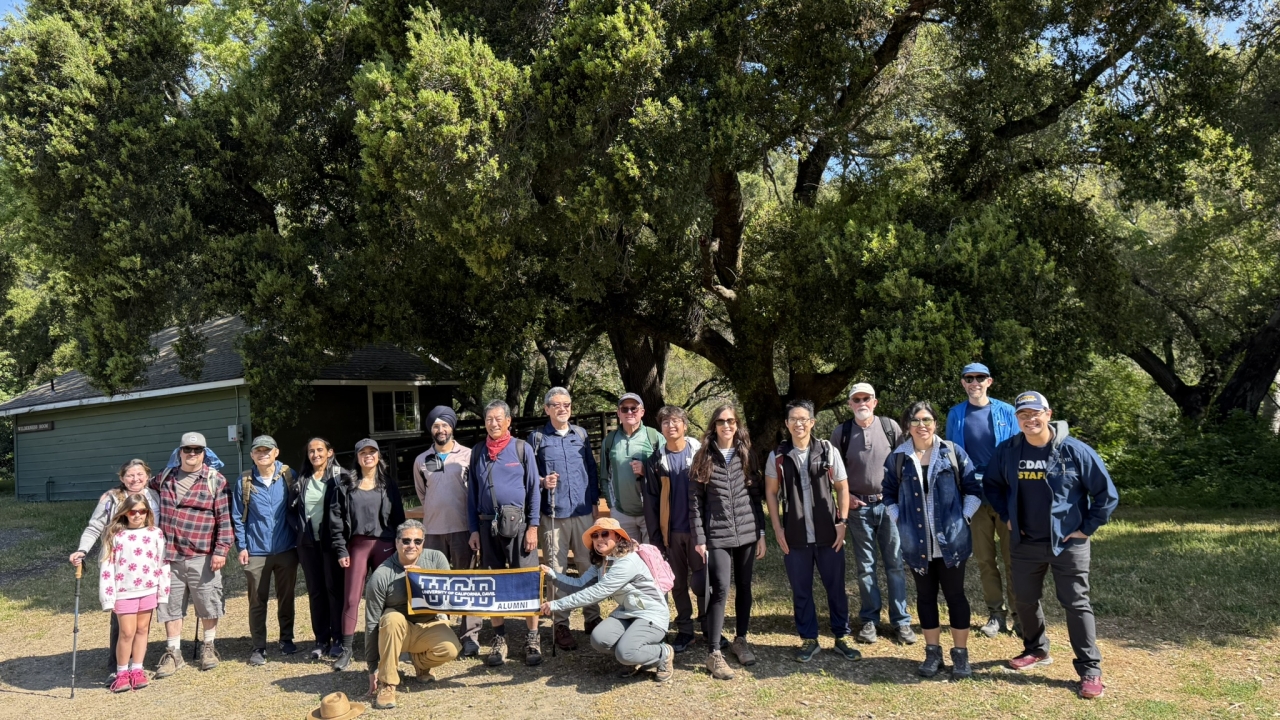 Photo of Alumni on a hike together holding a UC Davis Alumni Banner