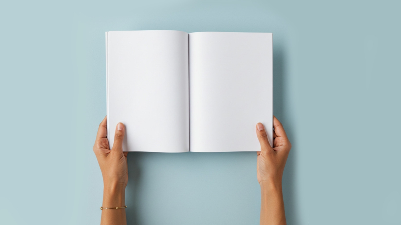 Hands holding open a book with empty pages