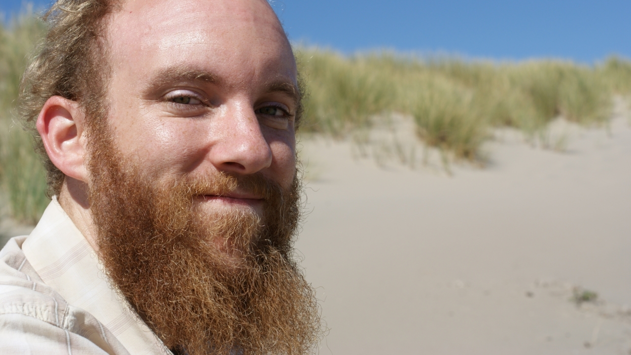 Lewis Lawyer smiling with sand dune in background.
