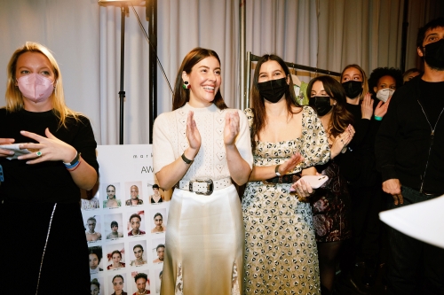 Group of masked people standing backstage at the New York fashion show.