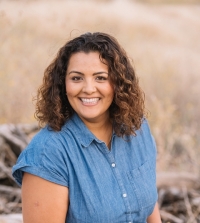Headshot of Anu Johl Singh wearing a blue denim button-down shirt outdoors.