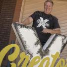 Shawn Sullivan standing with a Creator X sign