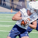 uc davis football player holding football 