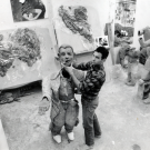 Black and white photo of Natsoulas in an art studio holding the head of his full-body sculpture.