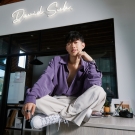 David Suh sitting on a desk at his studio in L.A.