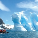 Aggie Travel members aboard a Zodiac craft observe the floating ice sculptures on the water's surface.