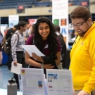 two students standing at a table looking at career information sheets