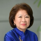 Middle-aged female with medium length hair in a bob hairstyle wearing a blue button down shirt with a vintage decorative detail.