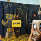 Student taking photo with Gunrock cutout holding "I'm In!" sign