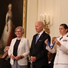 Sister Simone Campbell, J.D. ’77, left, stands ready to receive the Presidential Medal of Freedom (held by a military aide) from President Joe Biden, July 7, in the East Room of the White House. (Network Lobby for Catholic Social Justice)