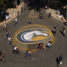 Students bike around a roundabout