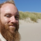 Lewis Lawyer smiling with sand dune in background.